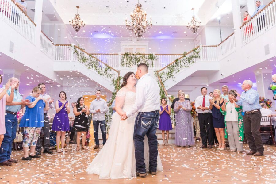 Bride and groom dance under confetti in Kendall Point ballroom.