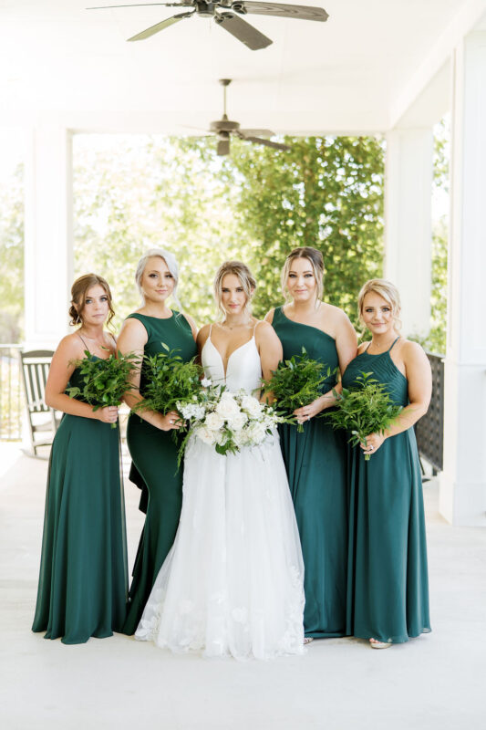 A bride and her bridesmaids in dark green dresses for a stunning fall wedding.