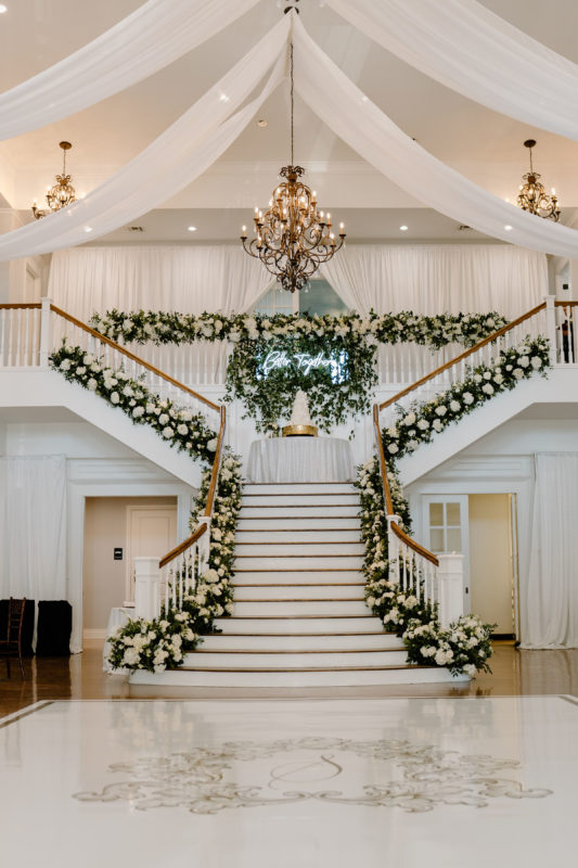 The staircase in the Kendall Point Grand Ballroom adorned with with flowers for an October wedding.