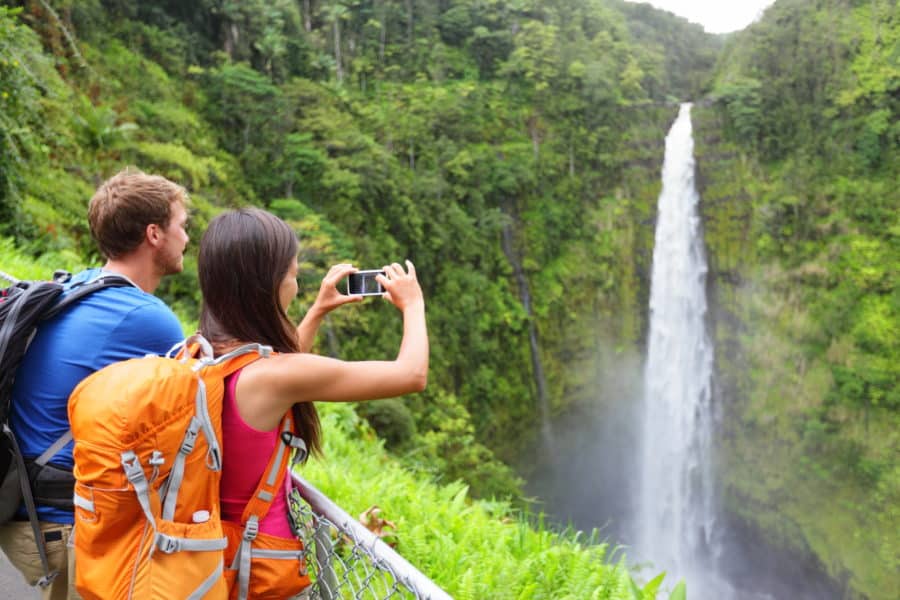 Couple hiking along a Hawaii waterfall.