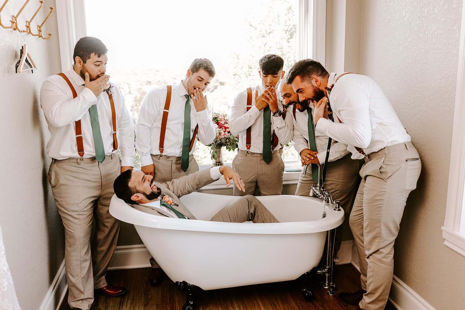groom and groomsmen in khaki pants with rust suspenders