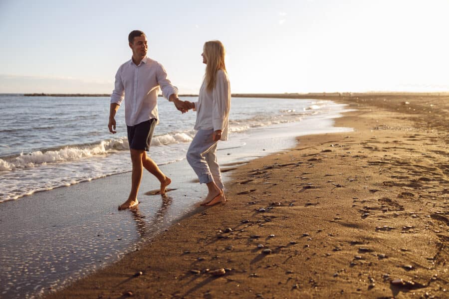 Couple walking on the beach for engagement photos