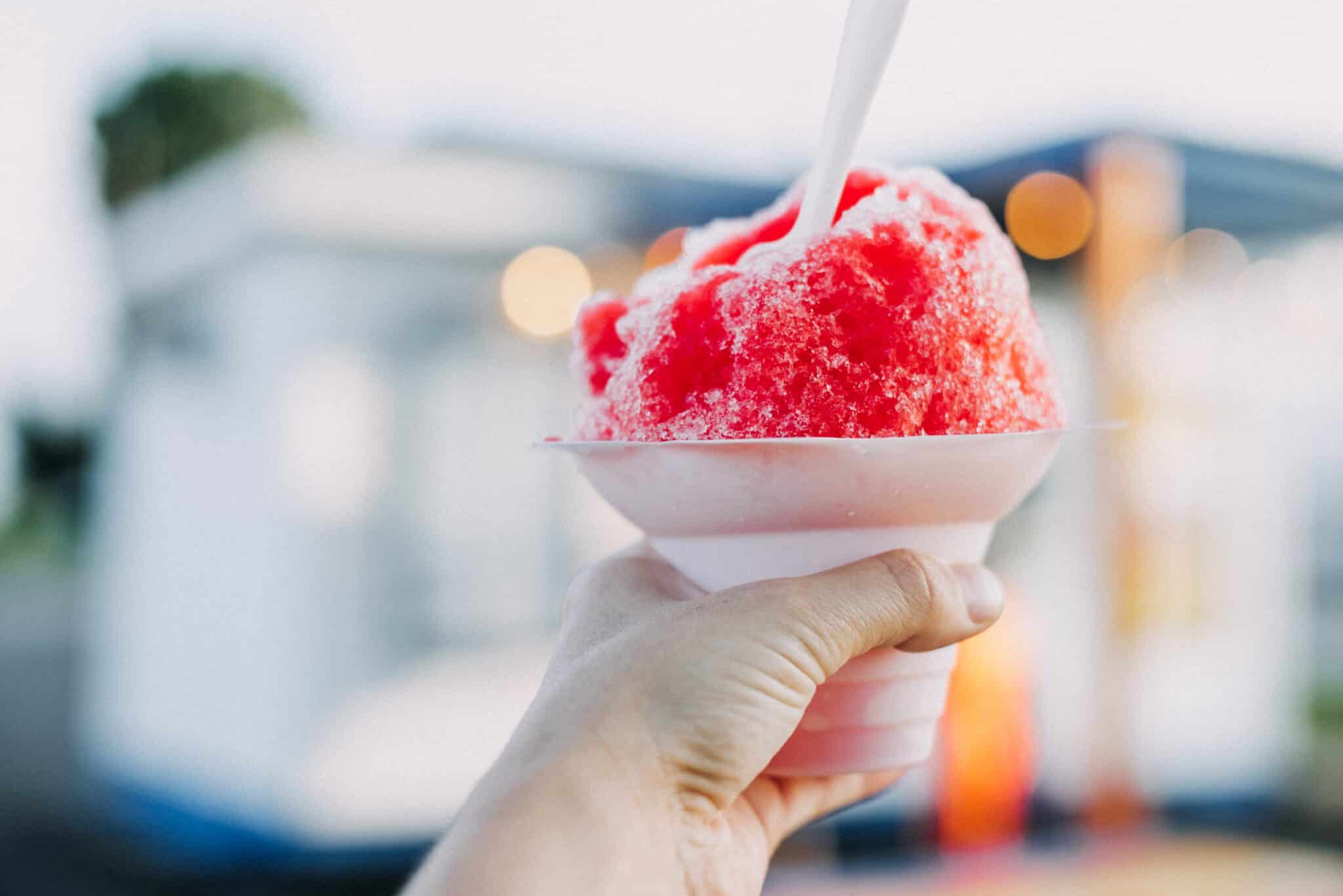 closeup of hand holding red snow cone