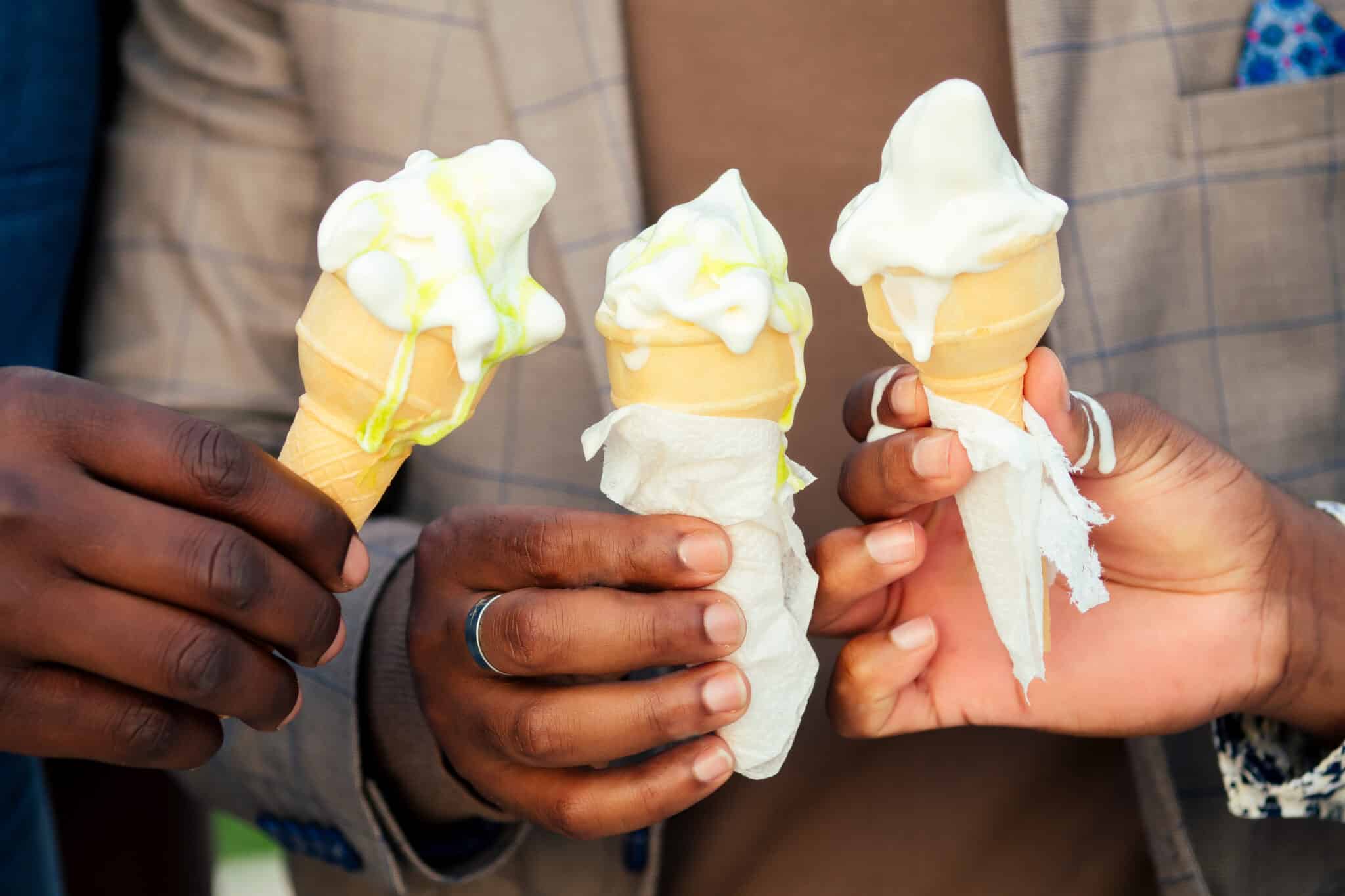 closeup for three wedding guests holding ice cream cones