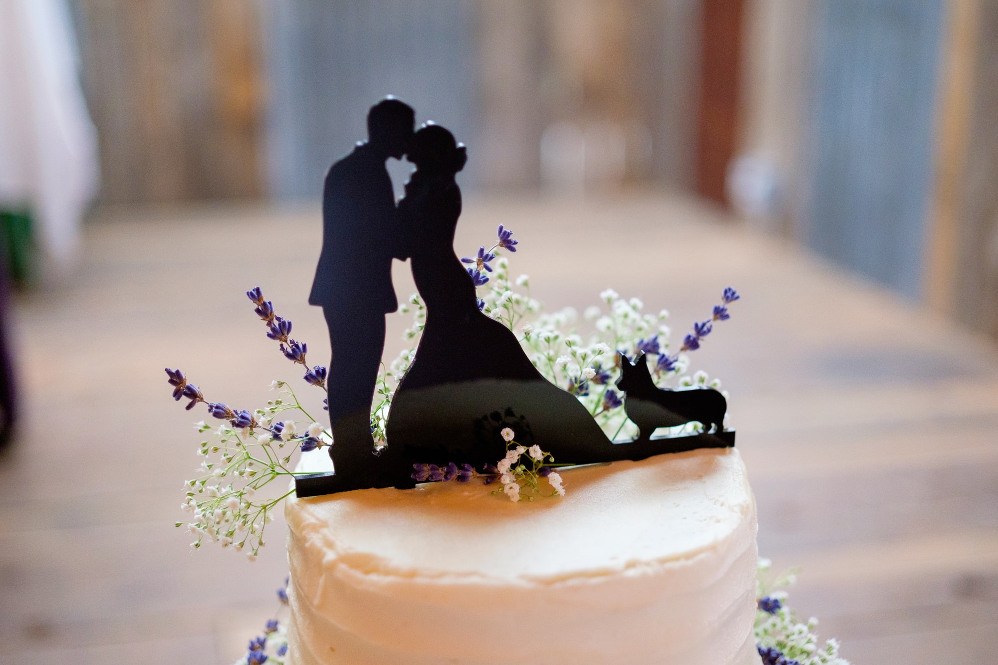 wedding cake topper in silhouette style of bride, groom, and dog