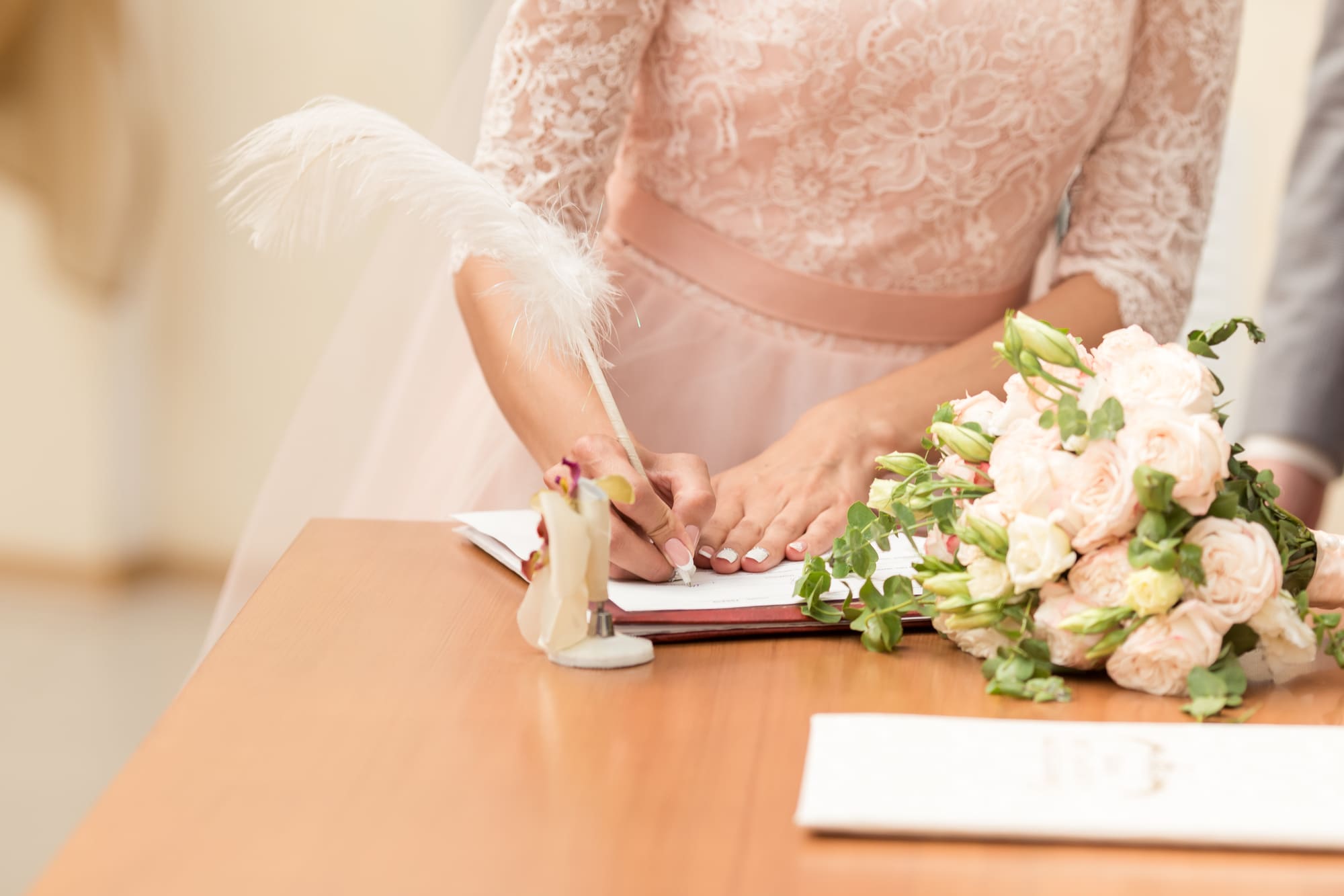 closeup of bride signing ketubah or wedding contract