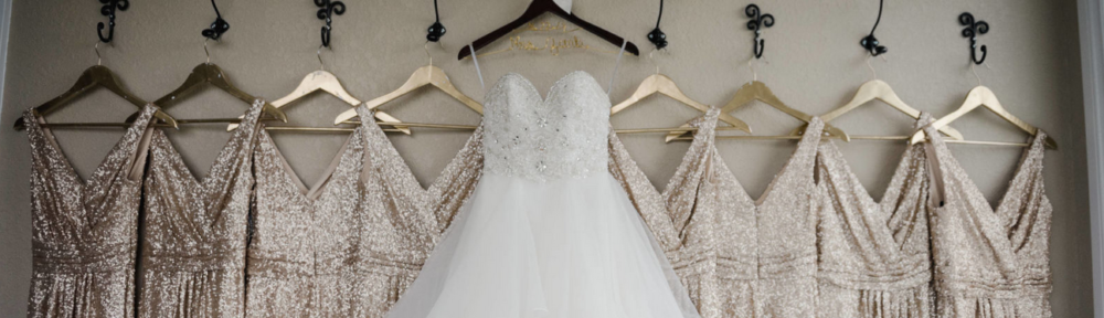 Wedding dress and gold bridesmaid dresses hanging in bridal suite at Kendall Point