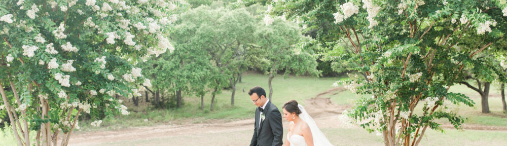A bride and groom walk along the Kendall Point grounds.