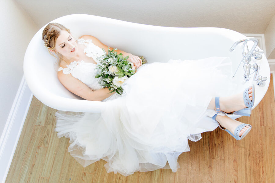 A bride sits in the clawfoot tub in the Kendall Point bridal suite.