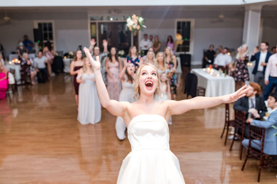 An excited bride tosses her bouquet. 