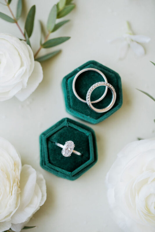 Emerald green velvet jewelry boxes and platinum rings. 