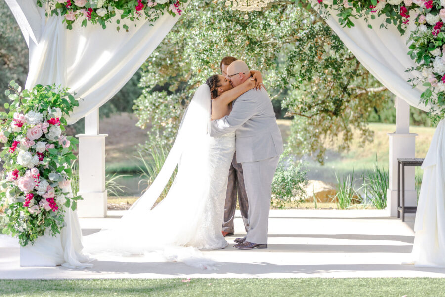 The bride and groom kiss under the gazebo.