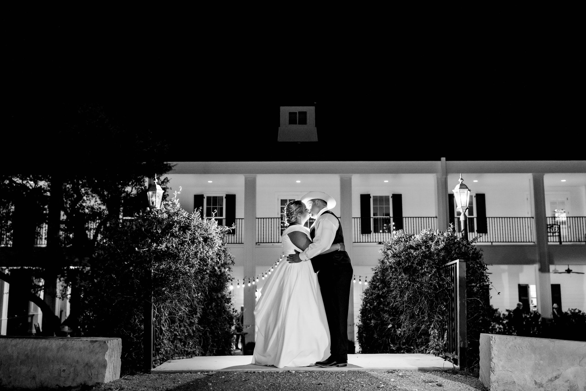 black and white photo of bride and groom kissing in front of Kendall Point