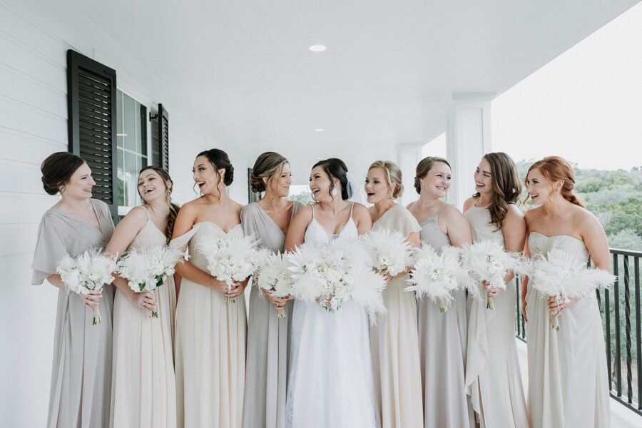 The bride and her bridesmaids all wearing white and off white. 