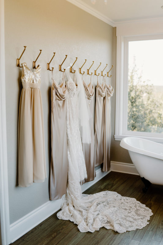 The wedding dress and bridesmaids dresses hang in the bridal suite.