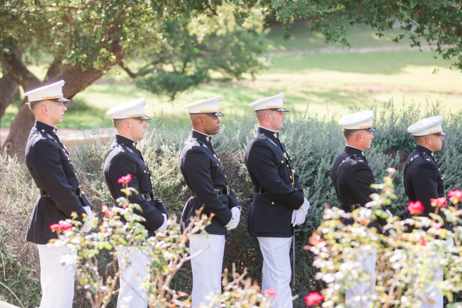 The groomsmen stand in their marine uniform.