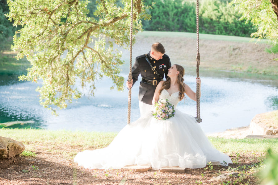 Groom pushes his bride on the outdoor swing at Kendall Point.