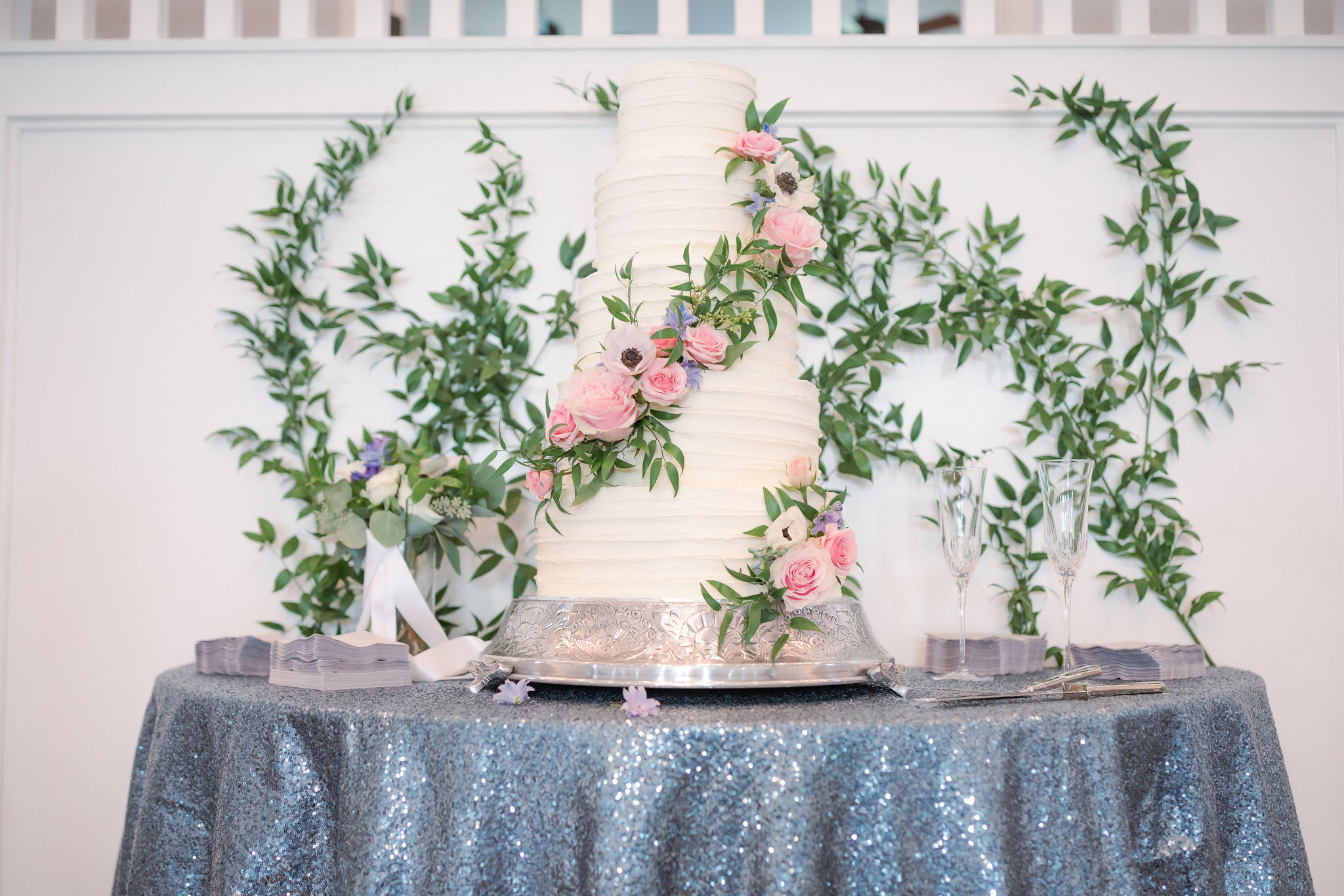 The wedding cake with pink flowers as decoration.