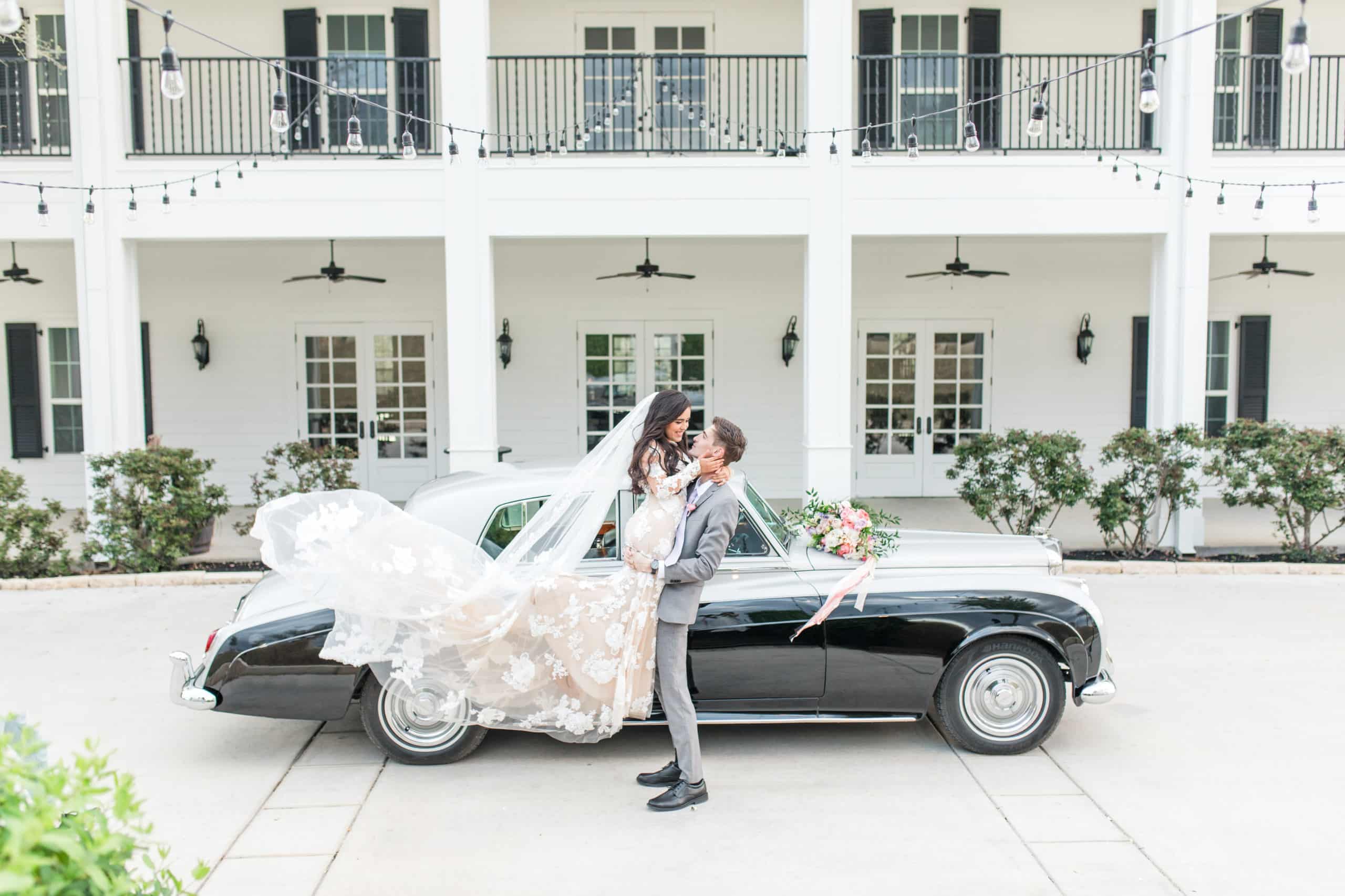Bride and groom outside Kendall Point wedding venue next to classic car