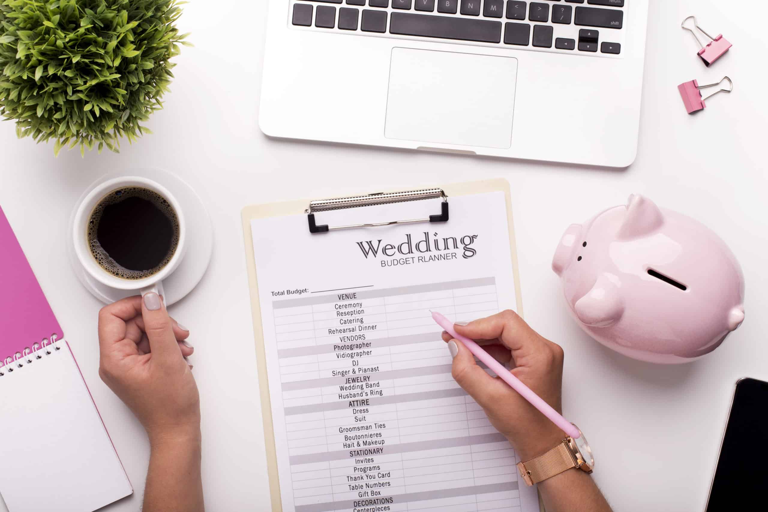 A woman making notes on a wedding checklist and budget planner.