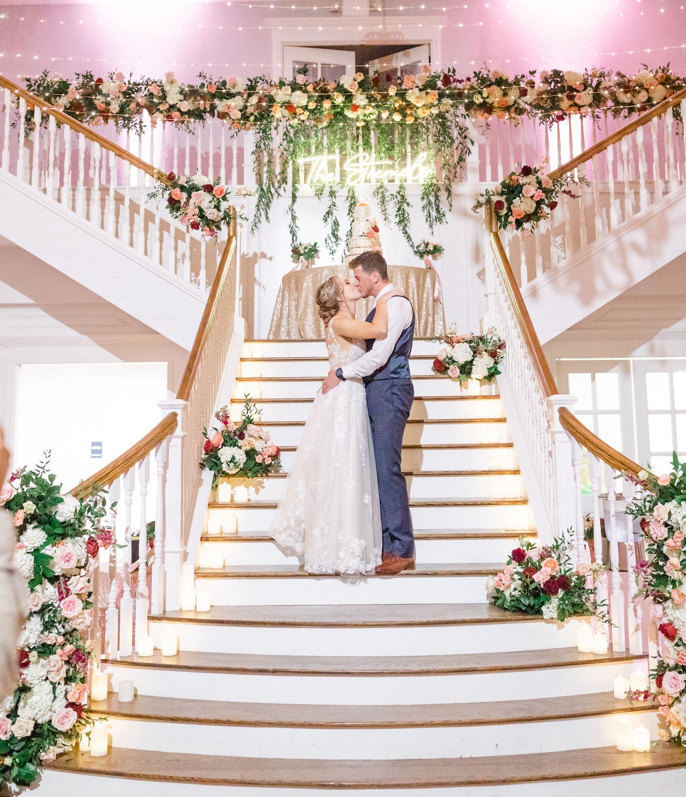 Bride and groom kiss on the Kendall Point grand staircase during their reception.