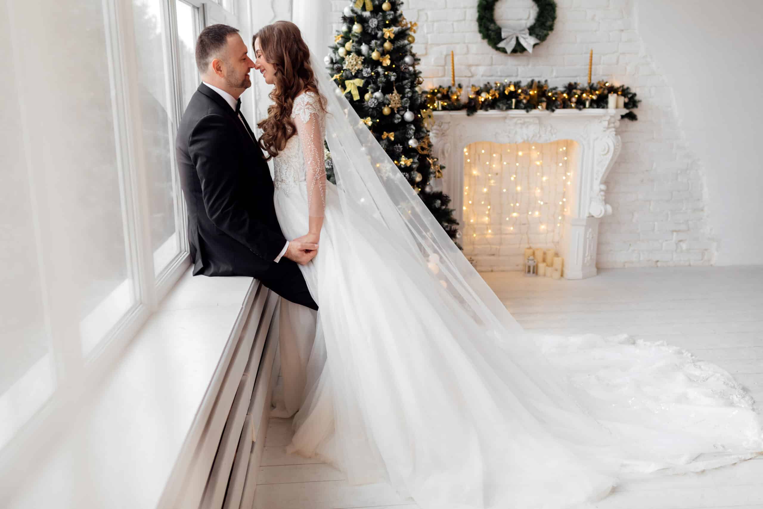 Bride and groom pose in front of a Christmas tree at their wedding