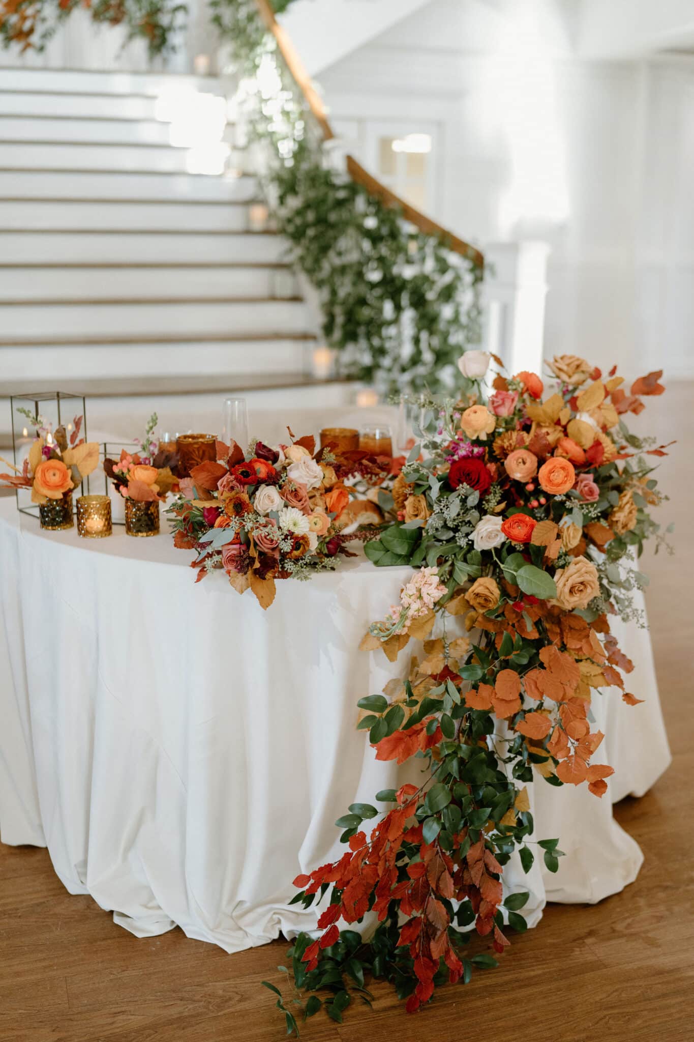 sweetheart table decorated with autumn florals and greenery