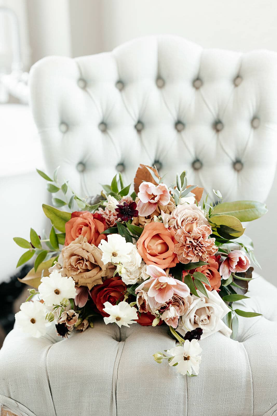 a bridal bouquet sitting on a velvet chair in the bridal suite