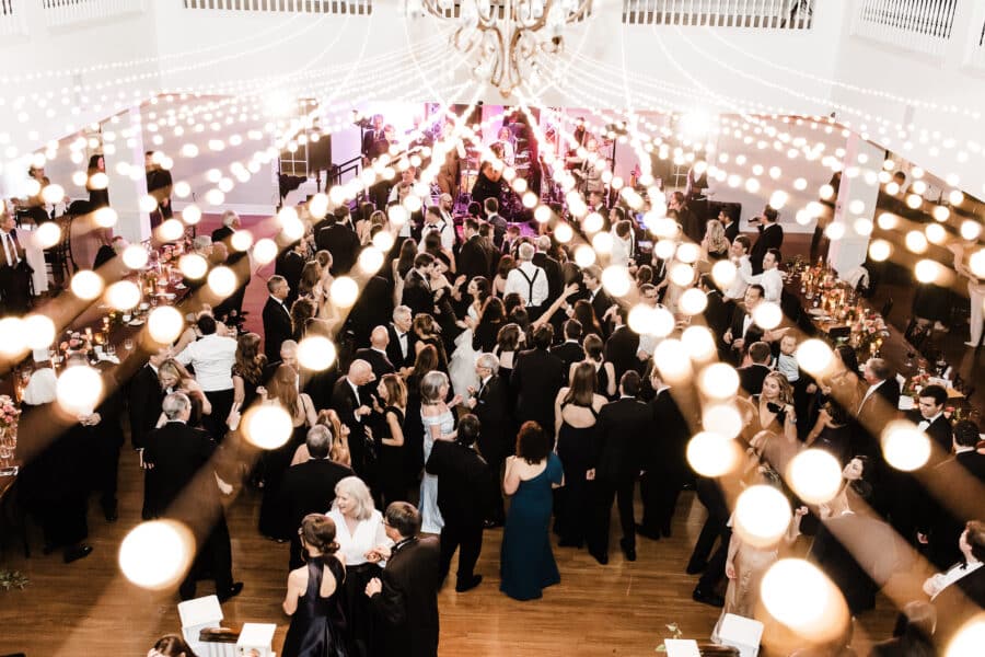 Wedding guests dance at Kendall Point wedding under string lights