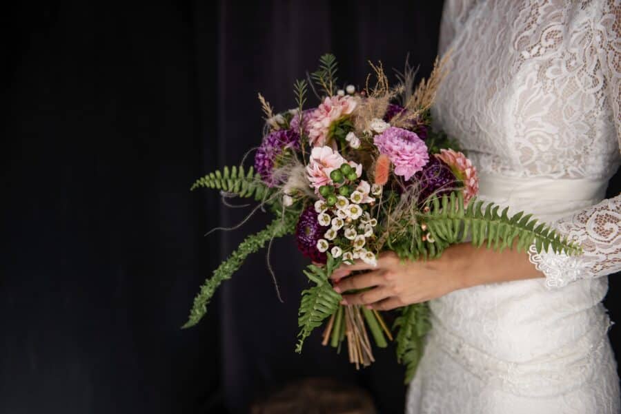 bride holding hand tied wedding bouquet