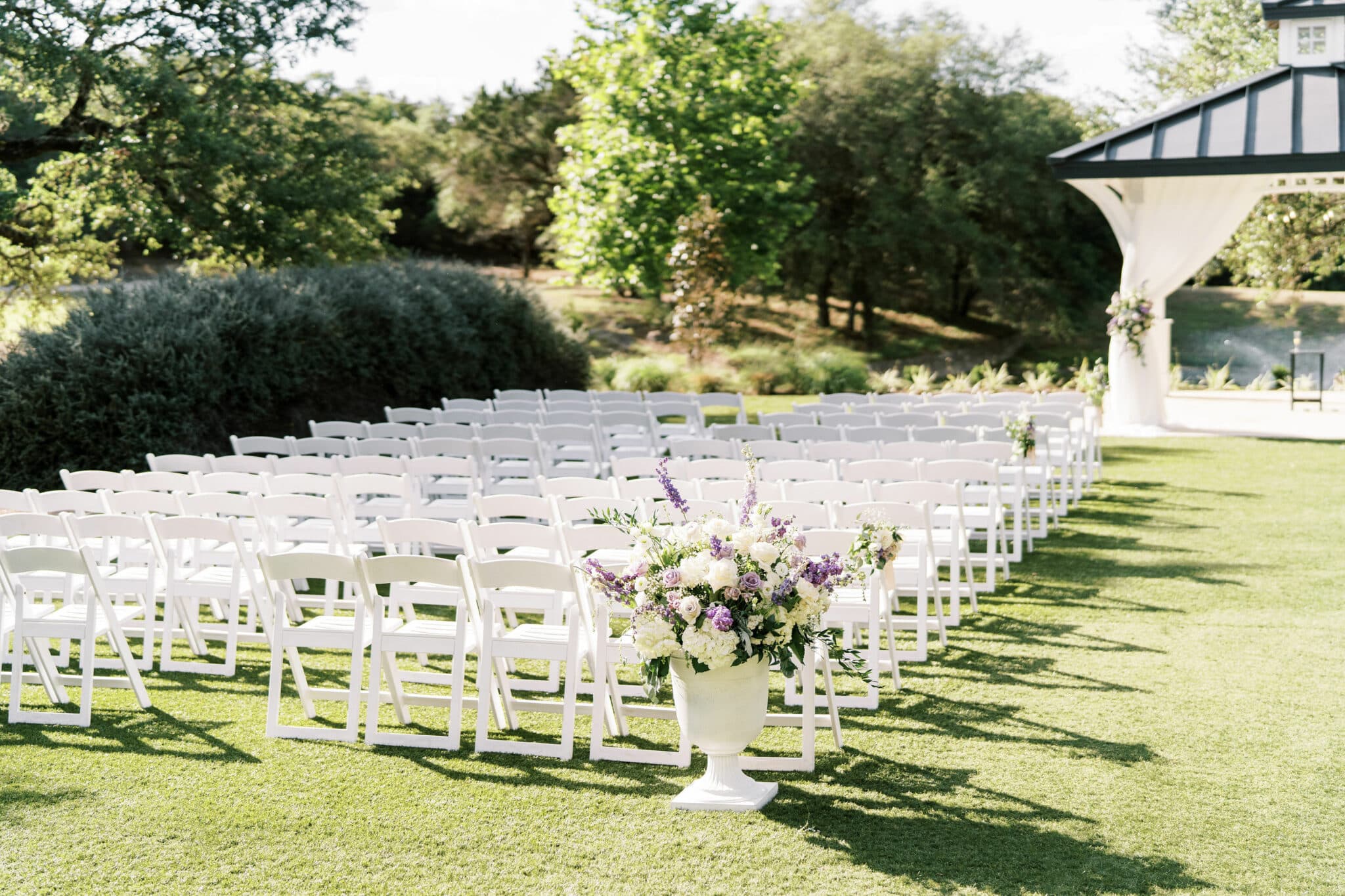 white chairs set up outside ready for a wedding ceremony