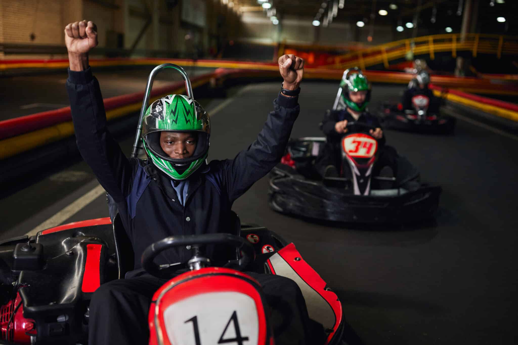 young men crossing the finish line in go karts