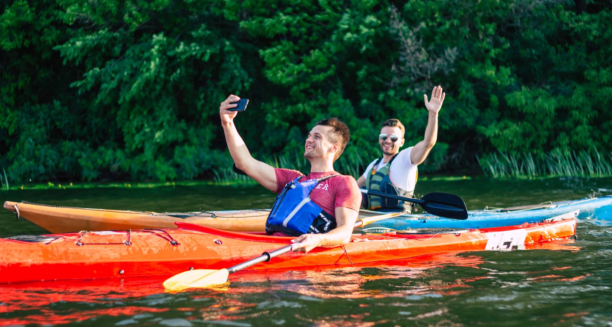 young men kayaking on river