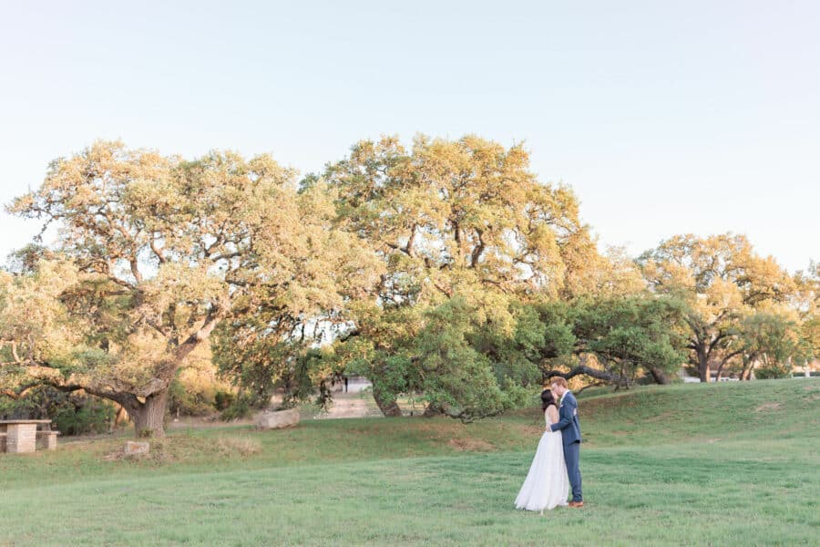 Bride and groom kissing in the rolling hills of Kendall Point